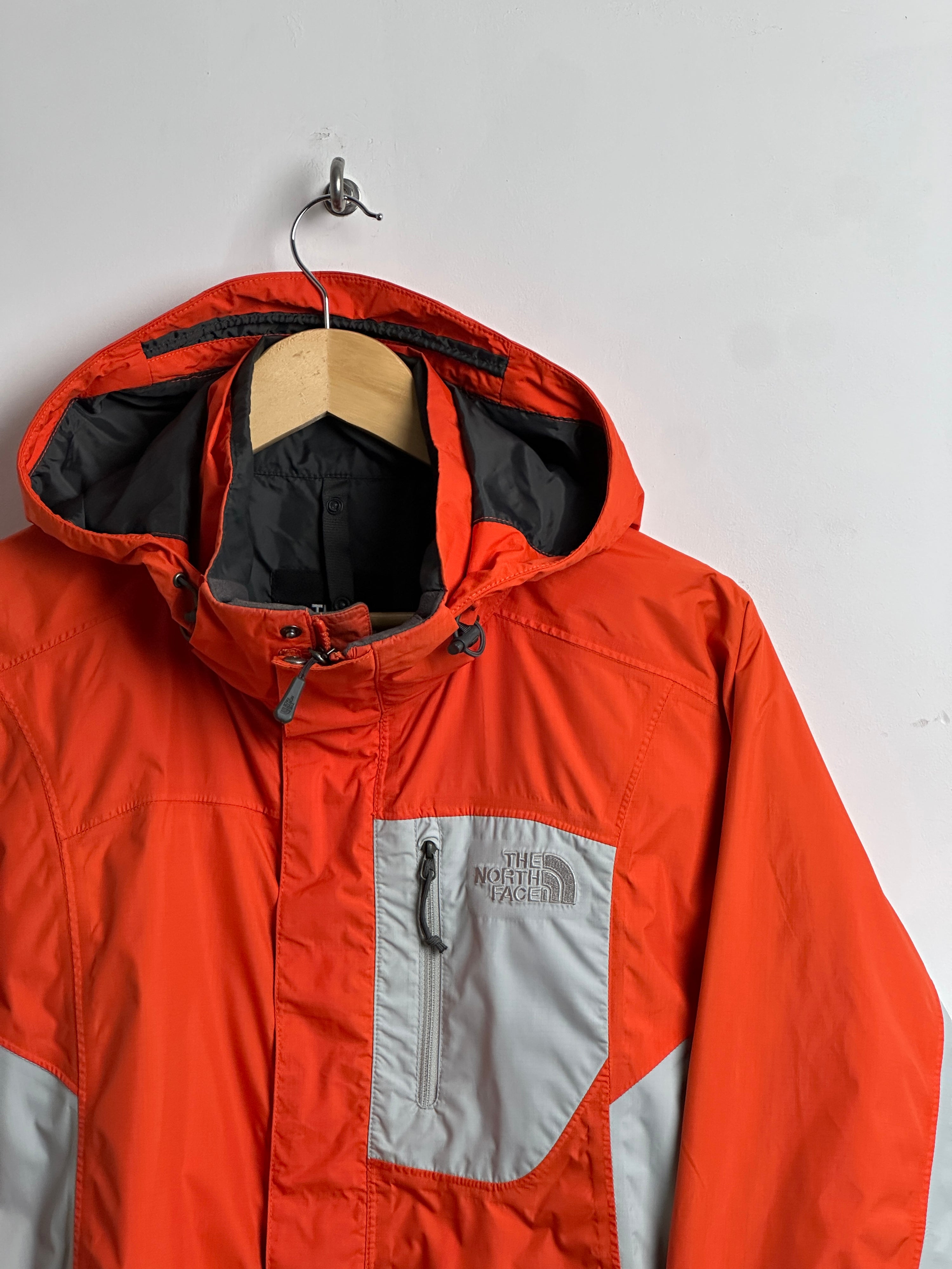 The North Face wind breaker in orange in grey