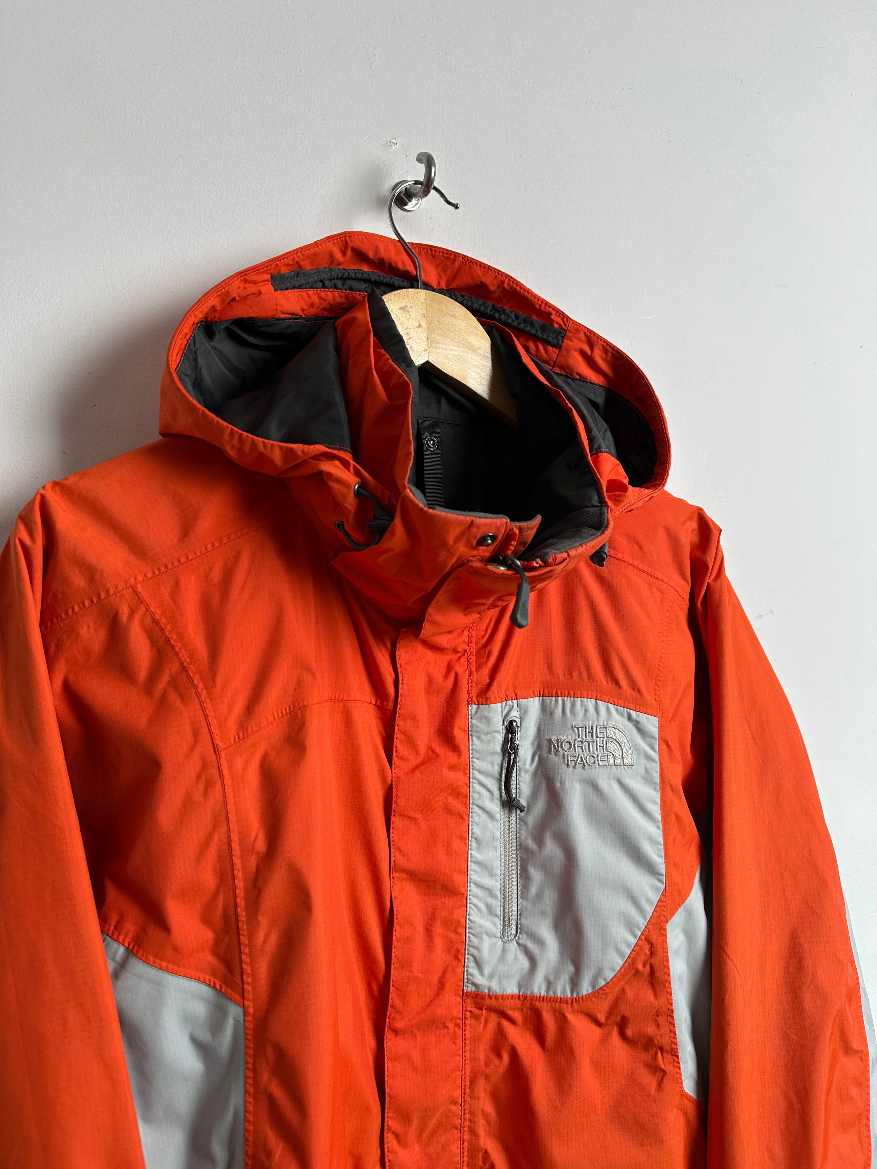 The North Face wind breaker in orange in grey